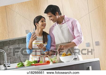 Happy couple preparing vegetable salad in kitchen View Large Photo Image Stock Image - Happy couple preparing vegetable salad in kitchen. Fotosearch