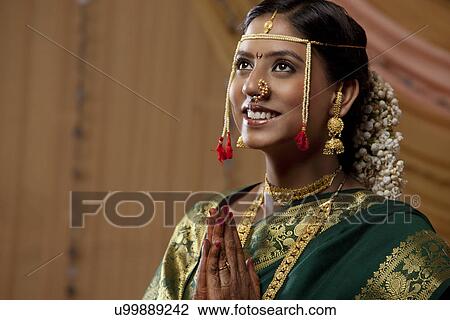 Happy Maharashtrian bride praying with her hands clasped View Large Photo Image Stock Image - Happy Maharashtrian bride praying with her hands clasped . Fotosearch