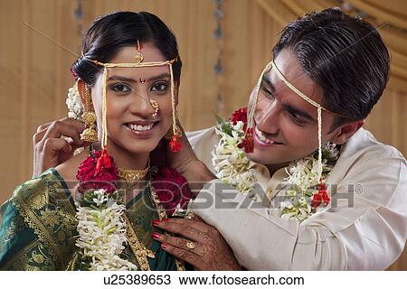 Happy newlywed couple performing marriage traditions View Large Photo Image Stock Image - Happy newlywed couple performing marriage traditions . Fotosearch