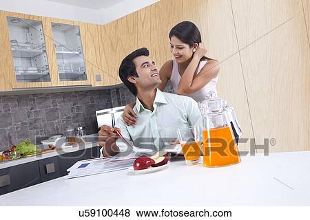 Happy young couple looking at each other in kitchen View Large Photo Image Stock Photo - Happy young couple looking at each other in kitchen. Fotosearch