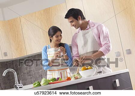 Indian couple preparing fresh vegetable salad in kitchen View Large Photo Image Picture - Indian couple preparing fresh vegetable salad in kitchen. Fotosearch