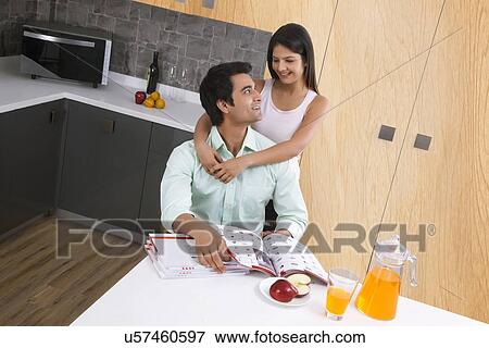 Loving couple looking at each other in kitchen View Large Photo Image Stock Photo - Loving couple looking at each other in kitchen. Fotosearch