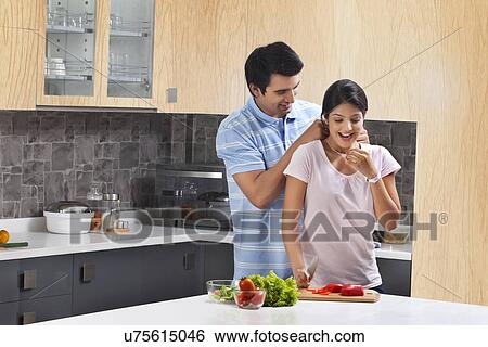 Loving man putting necklace on surprised woman in kitchen View Large Photo Image Stock Photograph - Loving man putting necklace on surprised woman in kitchen. Fotosearch