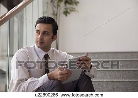Male executive with a tablet View Large Photo Image Stock Photograph - Male executive with a tablet. Fotosearch