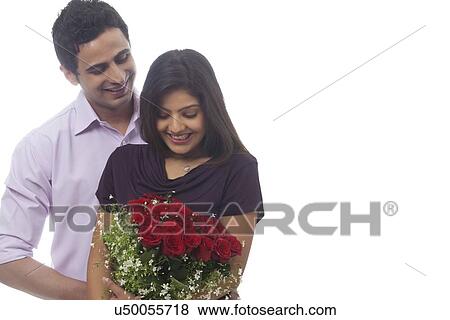 Stock Photo - Man giving a bouquet of roses to woman. Fotosearch