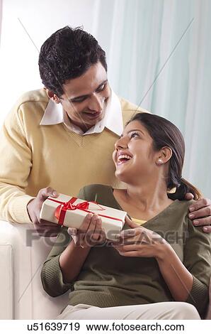 Man giving a gift to a woman on Valentines Day View Large Photo Image Stock Photo - Man giving a gift to a woman on Valentines Day. Fotosearch