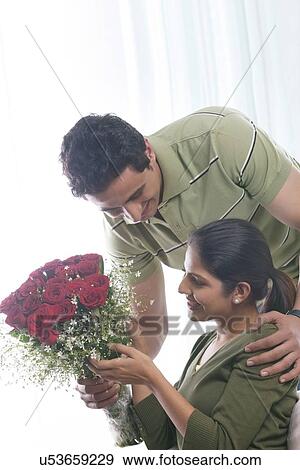 Man giving woman a bouquet of roses View Large Photo Image Stock Photo - Man giving woman a bouquet of roses. Fotosearch