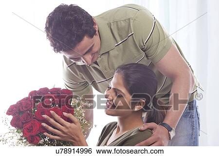 Stock Photograph - Man giving woman a bouquet of roses. Fotosearch