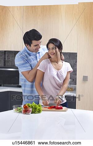 Man putting necklace on woman in kitchen View Large Photo Image Stock Image - Man putting necklace on woman in kitchen. Fotosearch