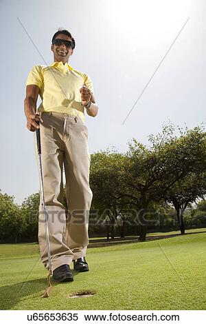 Stock Photography - Man with a golf club and golf ball . Fotosearch