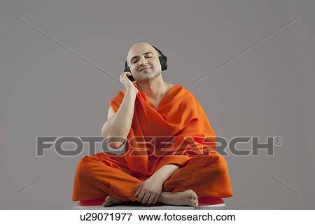 Stock Photo - Monk listening to music . Fotosearch