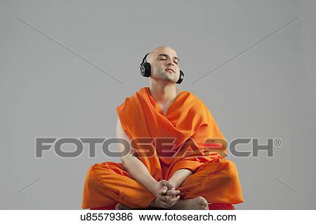 Stock Photograph - Monk listening to music . Fotosearch