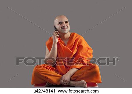 Stock Image - Monk talking on a mobile phone . Fotosearch