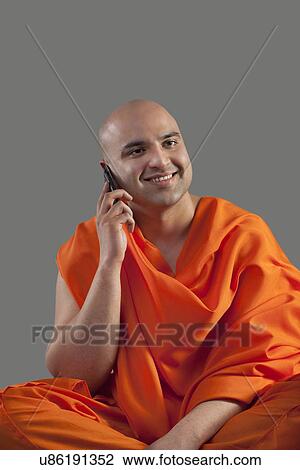 Monk talking on a mobile phone View Large Photo Image Stock Image - Monk talking on a mobile phone . Fotosearch