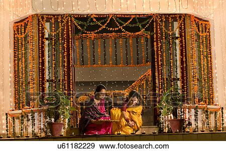 Stock Photo - Mother and daughter arranging diyas . Fotosearch