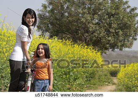 Picture - Mother and daughter enjoying in a field . Fotosearch