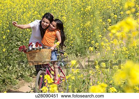 Stock Image - Mother and daughter enjoying in a field . Fotosearch