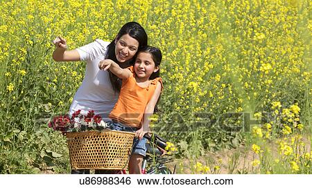 Mother and daughter enjoying in a field View Large Photo Image Stock Photograph - Mother and daughter enjoying in a field . Fotosearch