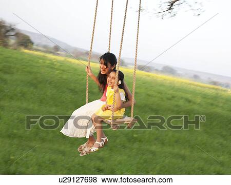 Mother and daughter having fun on a swing View Large Photo Image Stock Photo - Mother and daughter having fun on a swing . Fotosearch