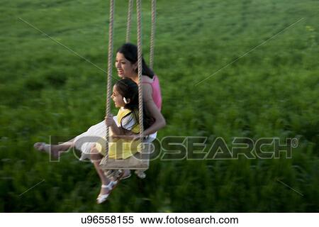 Stock Photography - Mother and daughter having fun on a swing . Fotosearch