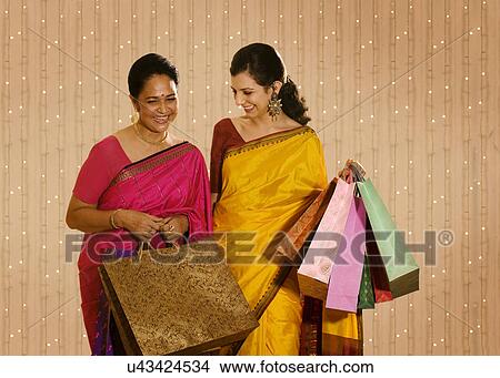 Mother and daughter holding shopping bags View Large Photo Image Picture - Mother and daughter holding shopping bags . Fotosearch