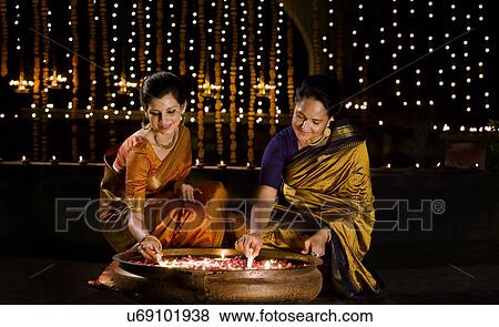 Mother and daughter lighting diyas View Large Photo Image Stock Photo - Mother and daughter lighting diyas . Fotosearch
