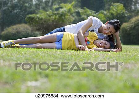 Picture - Mother and daughter lying on the grass . Fotosearch