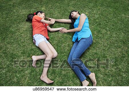 Stock Photo - Mother and daughter lying on the grass . Fotosearch