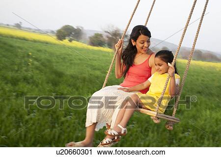 Stock Image - Mother and daughter on a swing . Fotosearch