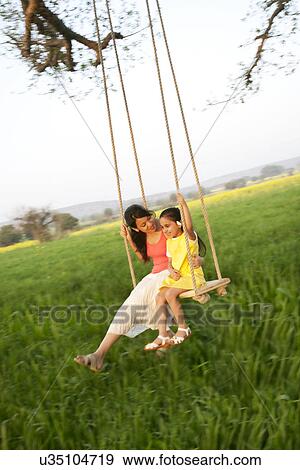 Stock Photo - Mother and daughter on a swing . Fotosearch
