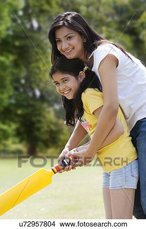 Mother and daughter playing cricket View Large Photo Image Picture - Mother and daughter playing cricket . Fotosearch