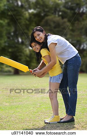 Mother and daughter playing cricket View Large Photo Image Stock Image - Mother and daughter playing cricket . Fotosearch