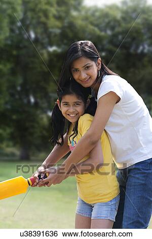 Mother and daughter playing cricket View Large Photo Image Stock Photograph - Mother and daughter playing cricket . Fotosearch