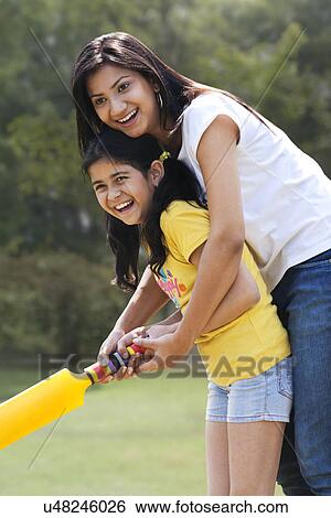 Stock Photograph - Mother and daughter playing cricket . Fotosearch