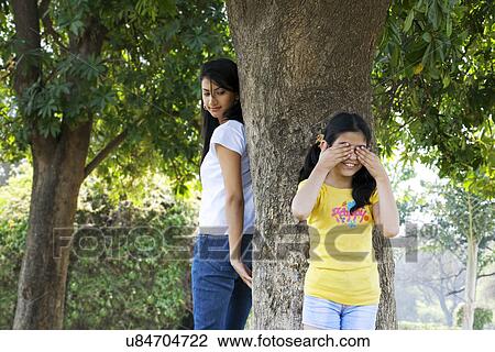 Stock Image - Mother and daughter playing hide and seek . Fotosearch