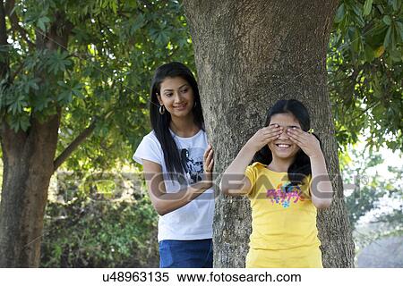 Stock Photography - Mother and daughter playing hide and seek . Fotosearch