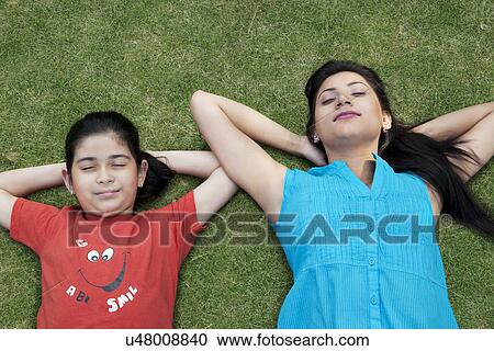 Mother and daughter relaxing on the grass View Large Photo Image Stock Image - Mother and daughter relaxing on the grass . Fotosearch