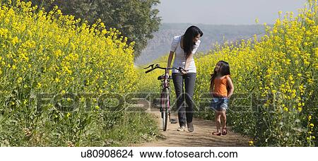 Picture - Mother and daughter walking in a field . Fotosearch