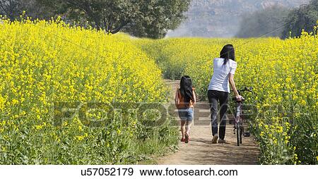 Stock Photo - Mother and daughter walking in a field . Fotosearch
