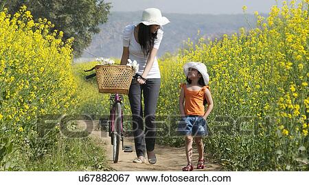 Stock Photo - Mother and daughter walking in a field . Fotosearch