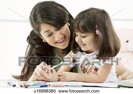 Stock Photography - Mother and daughter with a colouring book . Fotosearch