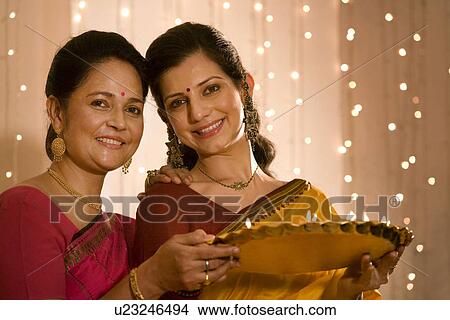 Mother and daughter with a tray of diyas View Large Photo Image Picture - Mother and daughter with a tray of diyas . Fotosearch