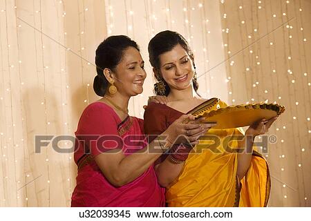 Mother and daughter with a tray of diyas View Large Photo Image Stock Photography - Mother and daughter with a tray of diyas . Fotosearch