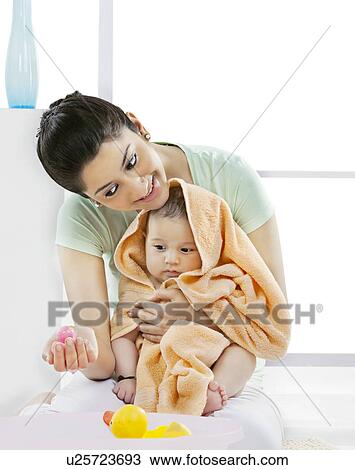 Mother and her baby looking at a rubber toy View Large Photo Image Stock Image - Mother and her baby looking at a rubber toy . Fotosearch