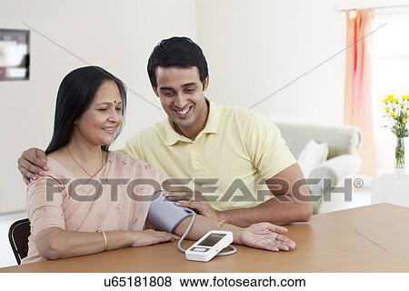 Mother and son looking at blood pressure gauge View Large Photo Image Stock Photo - Mother and son looking at blood pressure gauge . Fotosearch