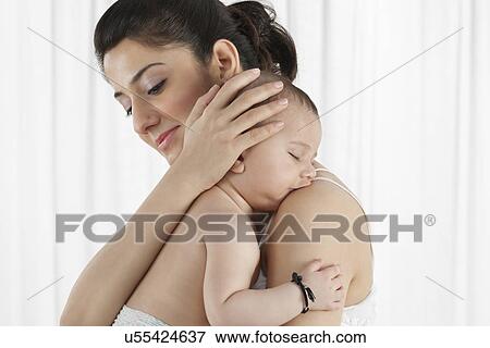 Mother holding a sleeping baby View Large Photo Image Stock Photo - Mother holding a sleeping baby . Fotosearch