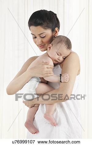 Mother holding a sleeping baby View Large Photo Image Stock Photo - Mother holding a sleeping baby . Fotosearch