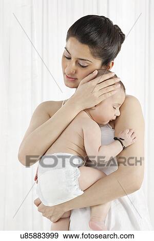 Mother holding a sleeping baby View Large Photo Image Stock Photo - Mother holding a sleeping baby . Fotosearch