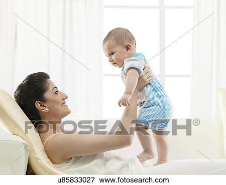 Mother holding her baby View Large Photo Image Stock Photo - Mother holding her baby . Fotosearch