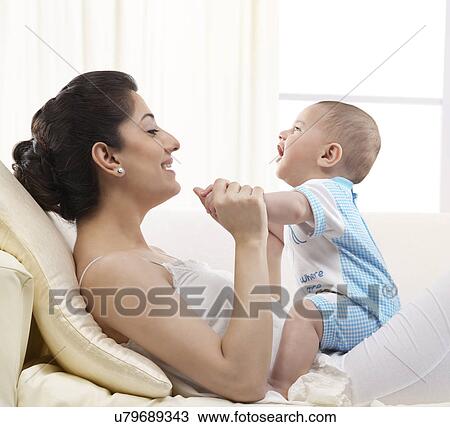 Stock Image - Mother playing with her baby . Fotosearch